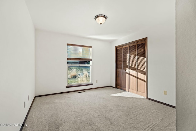 unfurnished bedroom featuring a closet, baseboards, visible vents, and carpet floors