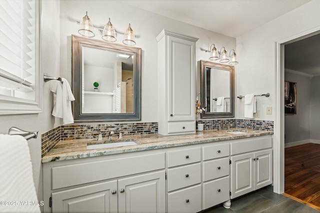 full bathroom with tasteful backsplash, wood finished floors, double vanity, and a sink