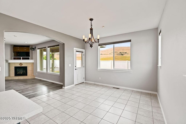 815 Trout Lake Ct, Yakima, WA 98901 - unfurnished dining area featuring a chandelier, healthy amount of natural light, arched walkways, and light tile patterned flooring
