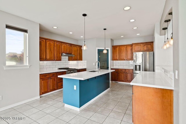 815 Trout Lake Ct, Yakima, WA 98901 - kitchen with stainless steel fridge, backsplash, light countertops, an island with sink, and under cabinet range hood