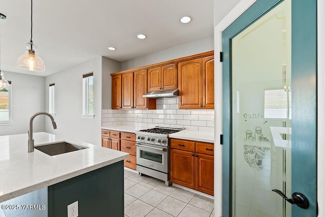 815 Trout Lake Ct, Yakima, WA 98901 - kitchen with high end stove, under cabinet range hood, backsplash, light tile patterned floors, and healthy amount of natural light