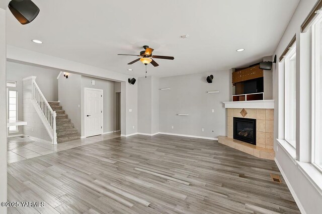 815 Trout Lake Ct, Yakima, WA 98901 - unfurnished living room featuring healthy amount of natural light, a tiled fireplace, a ceiling fan, recessed lighting, and wood finished floors