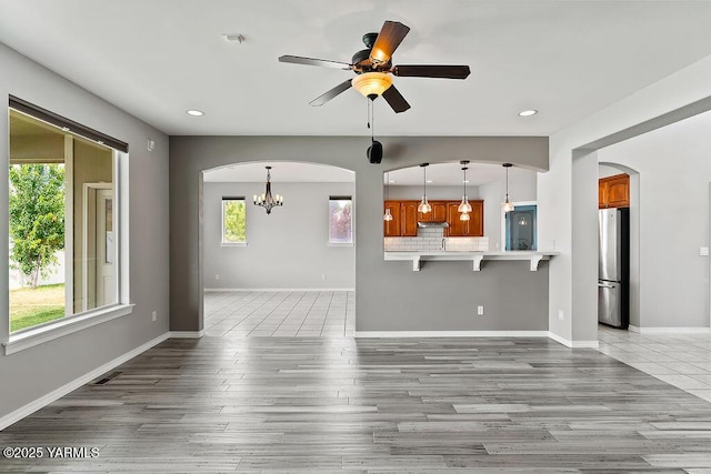 815 Trout Lake Ct, Yakima, WA 98901 - unfurnished living room featuring arched walkways, recessed lighting, ceiling fan, a chandelier, and wood finished floors