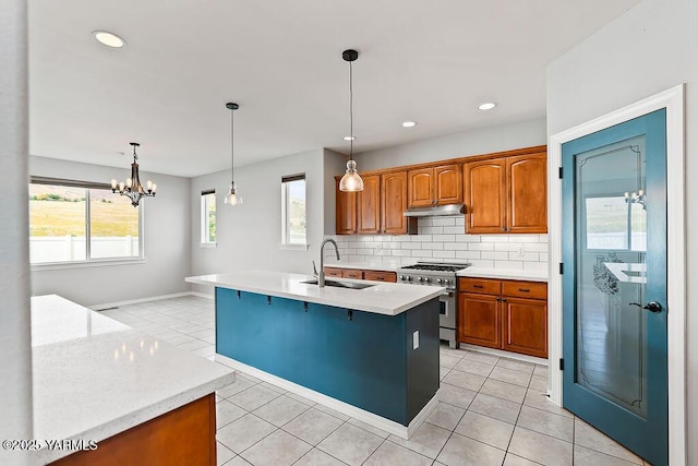 815 Trout Lake Ct, Yakima, WA 98901 - kitchen with stainless steel range, light tile patterned floors, backsplash, under cabinet range hood, and brown cabinetry