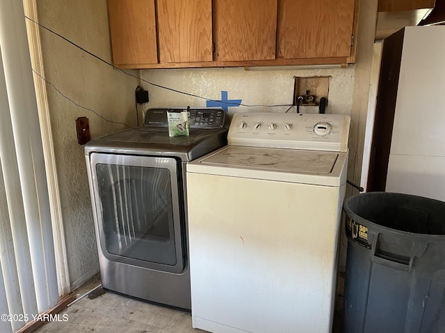 washroom with cabinet space, washing machine and dryer, and light wood-type flooring