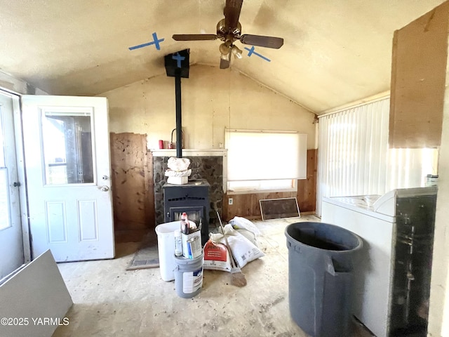 interior space with a ceiling fan and a wood stove