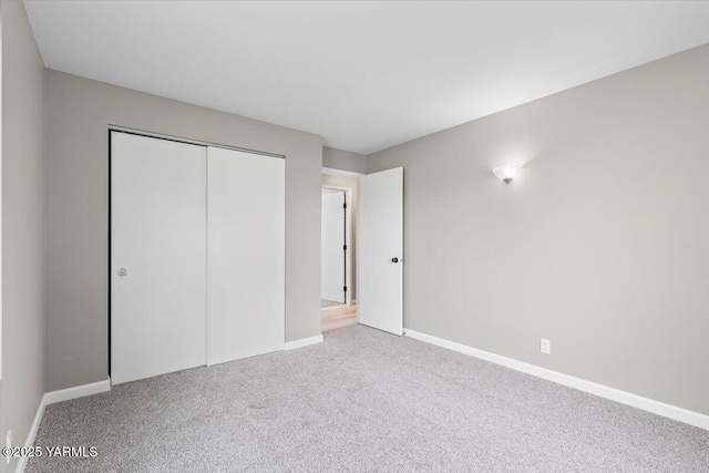unfurnished bedroom featuring baseboards, a closet, and carpet