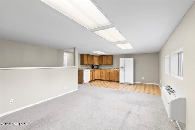 unfurnished living room with a wall mounted air conditioner, baseboards, and light carpet