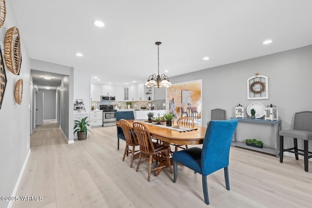 dining space with light wood-style flooring, baseboards, recessed lighting, and a chandelier