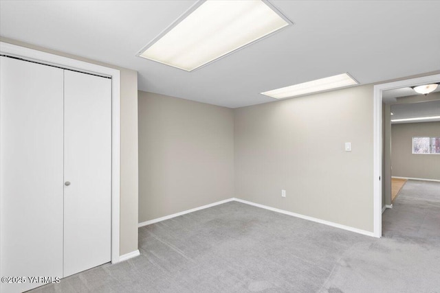 below grade area featuring baseboards and carpet flooring