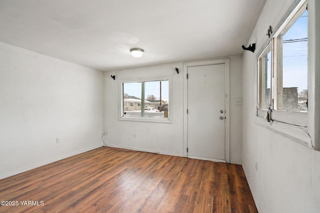 spare room with dark wood finished floors and baseboards