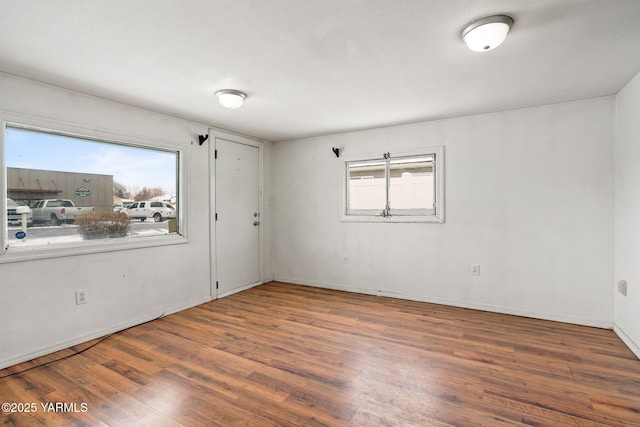 empty room featuring dark wood finished floors and baseboards