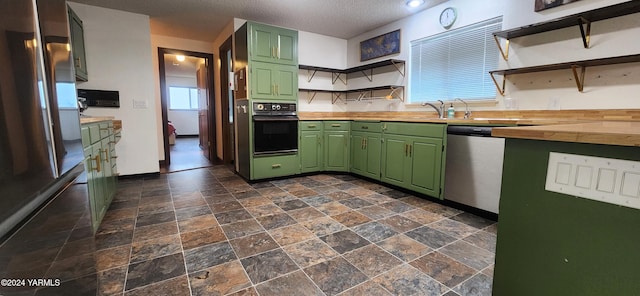 kitchen featuring stainless steel appliances, butcher block counters, open shelves, and green cabinetry