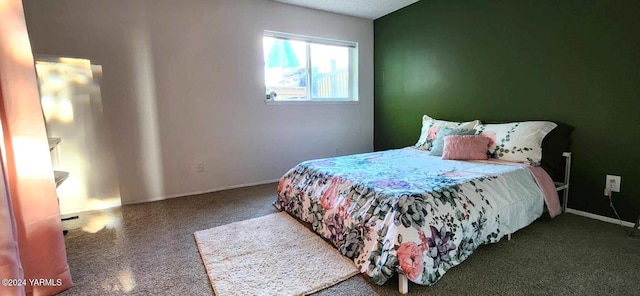 bedroom featuring dark colored carpet and baseboards