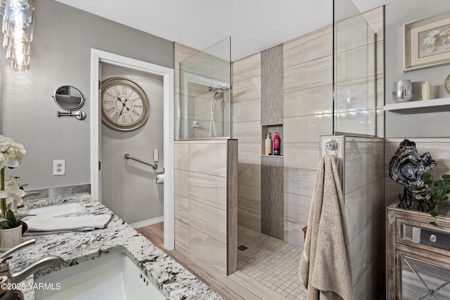 bathroom featuring double vanity, walk in shower, and a sink