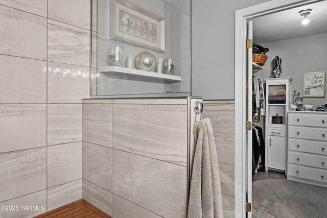 interior space featuring walk in shower and a walk in closet