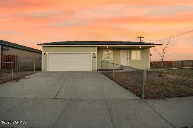 view of front of home with a fenced front yard, concrete driveway, and a garage