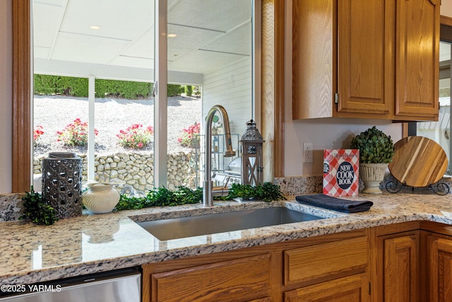 6 N 78th Ave, Yakima, WA 98908 - kitchen with stainless steel dishwasher, light stone countertops, and brown cabinetry