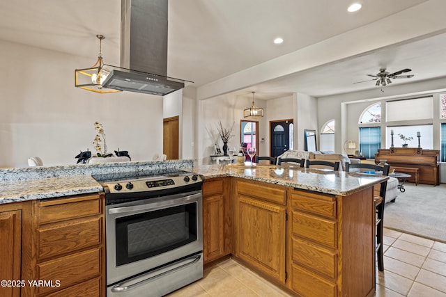 6 N 78th Ave, Yakima, WA 98908 - kitchen featuring stainless steel electric stove, island exhaust hood, brown cabinetry, a kitchen bar, and light tile patterned floors