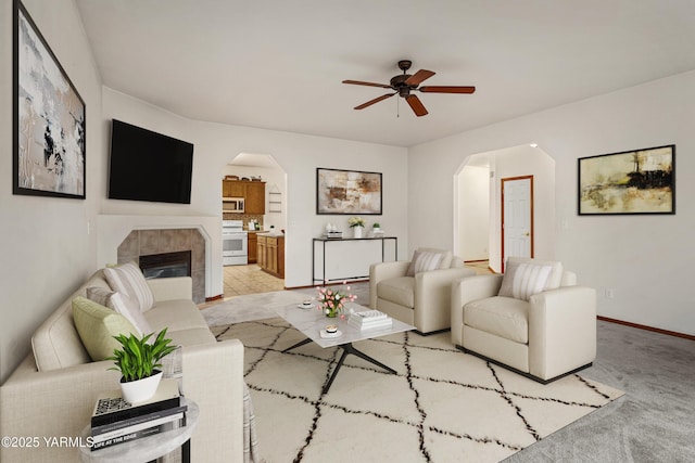 408 S 93rd Ave, Yakima, WA 98908 - living area with ceiling fan, light colored carpet, a fireplace, arched walkways, and baseboards