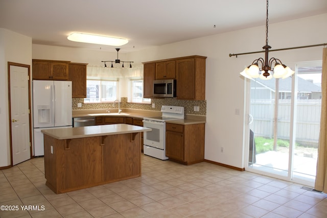 408 S 93rd Ave, Yakima, WA 98908 - kitchen featuring pendant lighting, appliances with stainless steel finishes, backsplash, and a chandelier