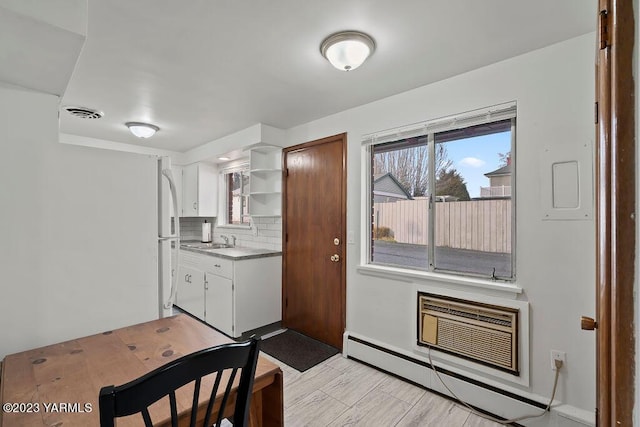 1501 W Chestnut Ave Unit 5, Yakima, WA 98902 - kitchen featuring a baseboard radiator, backsplash, open shelves, white cabinets, and a wall mounted AC