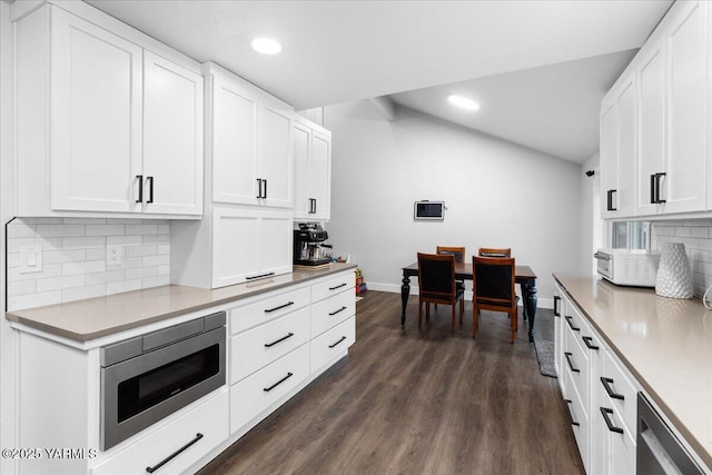 kitchen featuring baseboards, dark wood-style flooring, white cabinets, appliances with stainless steel finishes, and tasteful backsplash