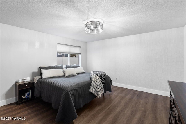 bedroom with a textured ceiling, dark wood-type flooring, and baseboards