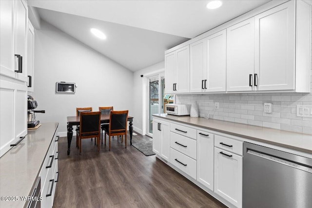 kitchen featuring vaulted ceiling, dark wood-style flooring, light countertops, and stainless steel dishwasher