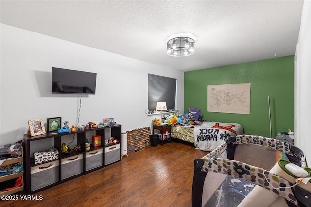 bedroom with wood finished floors and a textured ceiling