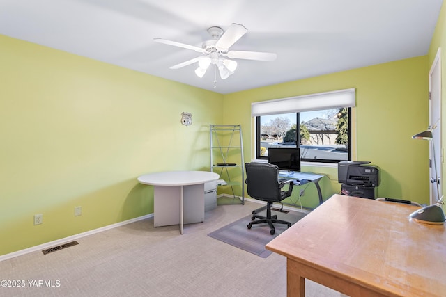 home office with baseboards, ceiling fan, visible vents, and light colored carpet