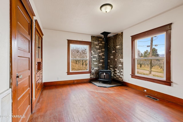 1555 W Tieton Rd, Tieton, WA 98947 - unfurnished room with a wood stove, hardwood / wood-style floors, and baseboards