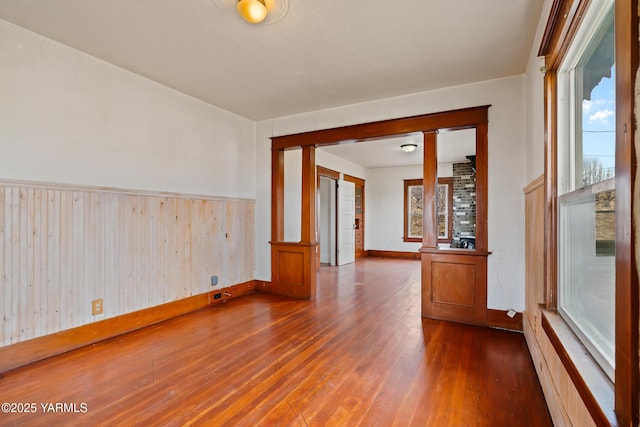 1555 W Tieton Rd, Tieton, WA 98947 - unfurnished room featuring wood finished floors, ornate columns, baseboards, wainscoting, and wooden walls