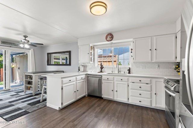 602 N 57th Ave, Yakima, WA 98901 - kitchen with appliances with stainless steel finishes, a peninsula, dark wood finished floors, and white cabinetry