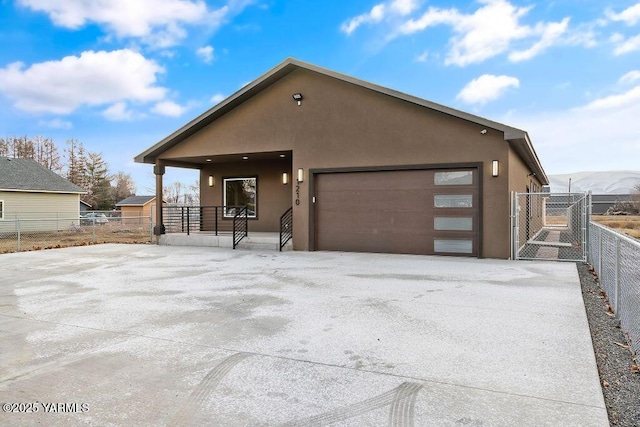 chalet / cabin featuring a garage, a porch, fence, and stucco siding