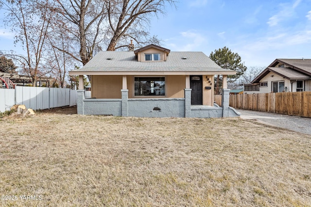 bungalow-style home with a chimney, fence, and a front lawn