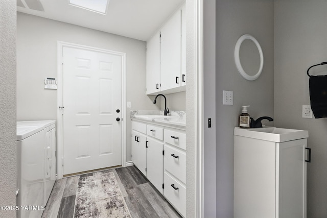 15014 Fisk Rd, Yakima, WA 98908 - laundry area with independent washer and dryer, light wood-style flooring, and cabinet space