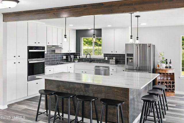 15014 Fisk Rd, Yakima, WA 98908 - kitchen with stainless steel appliances, wood finished floors, baseboards, backsplash, and recessed lighting