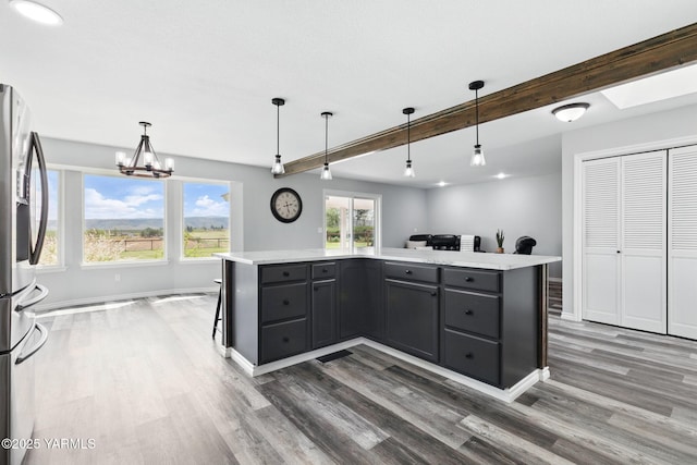 15014 Fisk Rd, Yakima, WA 98908 - kitchen with stainless steel refrigerator with ice dispenser, wood finished floors, beamed ceiling, light countertops, and a kitchen island