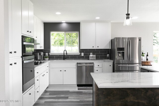 15014 Fisk Rd, Yakima, WA 98908 - kitchen with stainless steel appliances, a sink, light stone countertops, light wood finished floors, and white cabinets
