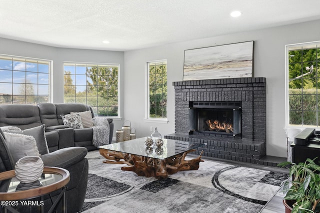 15014 Fisk Rd, Yakima, WA 98908 - living area with healthy amount of natural light, recessed lighting, a brick fireplace, a textured ceiling, and wood finished floors