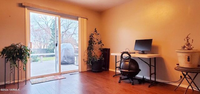 home office with baseboards, wood finished floors, and a healthy amount of sunlight