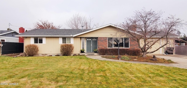 single story home with driveway, brick siding, a chimney, and a front yard