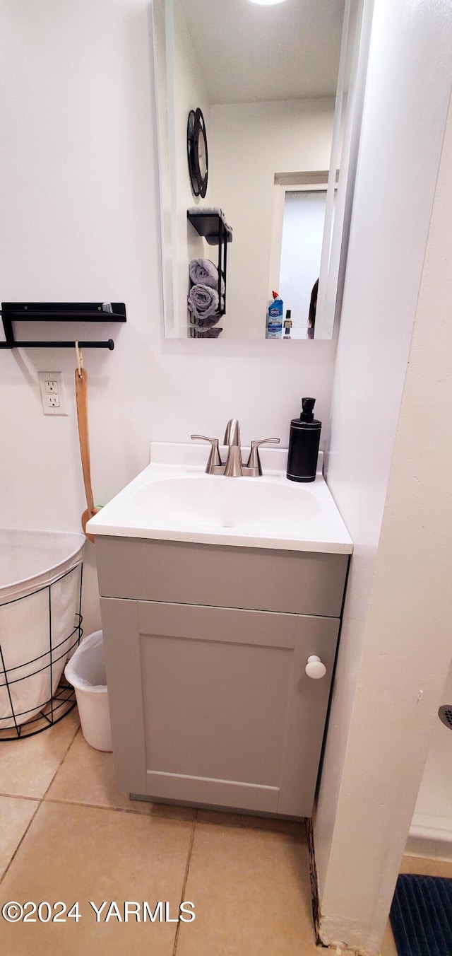 half bath with toilet, tile patterned floors, and vanity