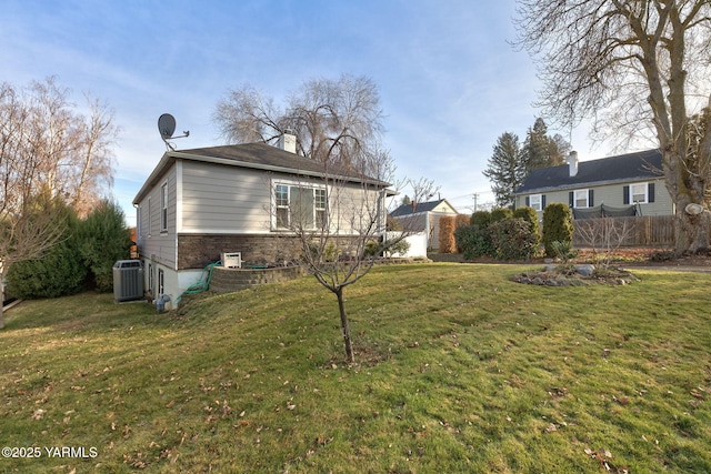 exterior space with a yard, central AC unit, and fence