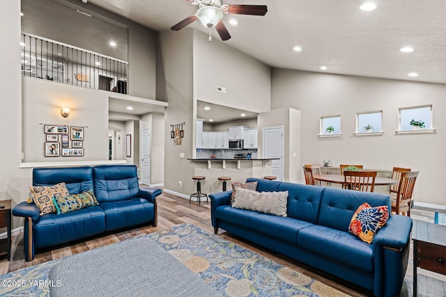 living area featuring recessed lighting, ceiling fan, baseboards, and wood finished floors