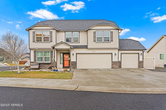 craftsman house with concrete driveway, stone siding, and a shingled roof