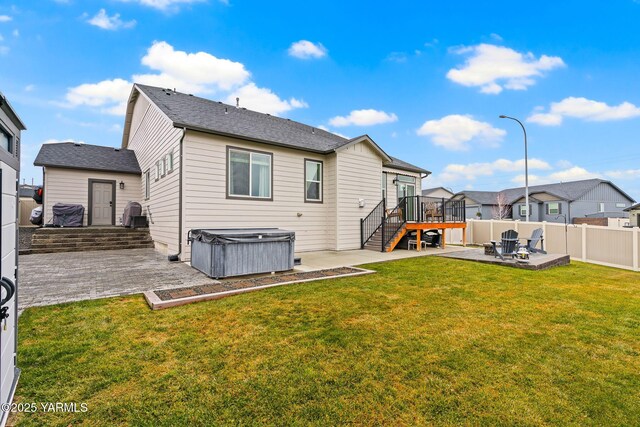 rear view of property featuring a patio, stairway, a yard, a fenced backyard, and a hot tub