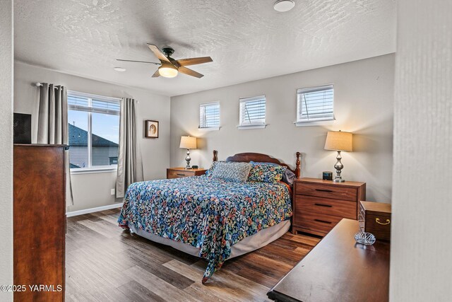 bedroom with multiple windows, a textured ceiling, and wood finished floors