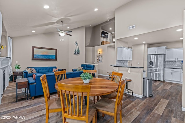 dining space featuring dark wood finished floors, recessed lighting, a fireplace, and visible vents